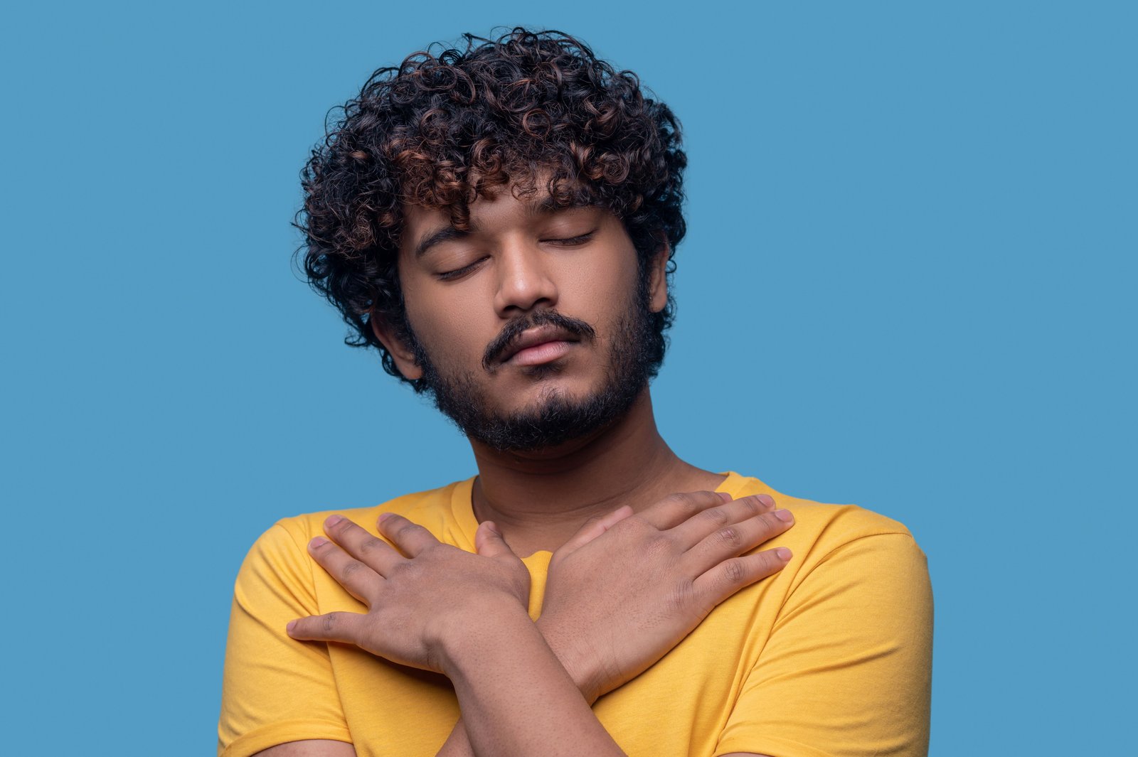 “Los hombres también sienten” una reflexión frente a la salud mental masculina 3 Salud mental masculina. retrato de un joven sereno con los ojos cerrados de pie contra el fondo azul